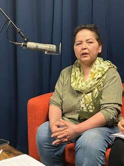 Woman sitting in chair talking into microphone